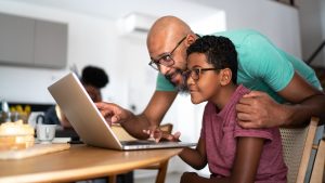 Parent helping child on computer