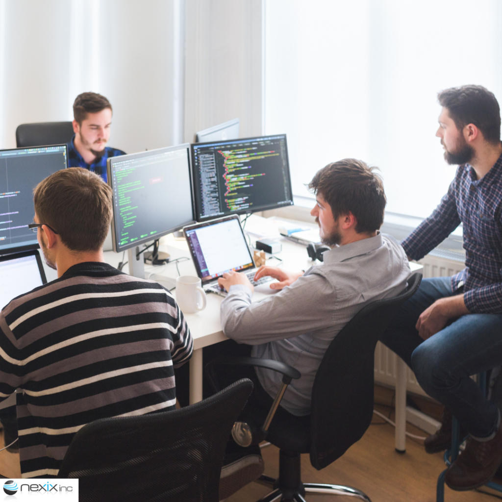 3 men working on their computers with another looking at their computers