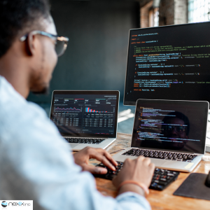 Man coding on 3 screens at a desk