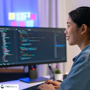 Woman coding at a desk in a multicolored lights environment