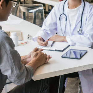 A doctor and a patient talking with a tablet in between