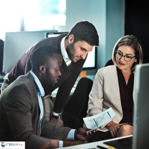 2 men 1 woman looking at a paper report in an office