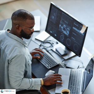 Man working on a computer and laptop coding