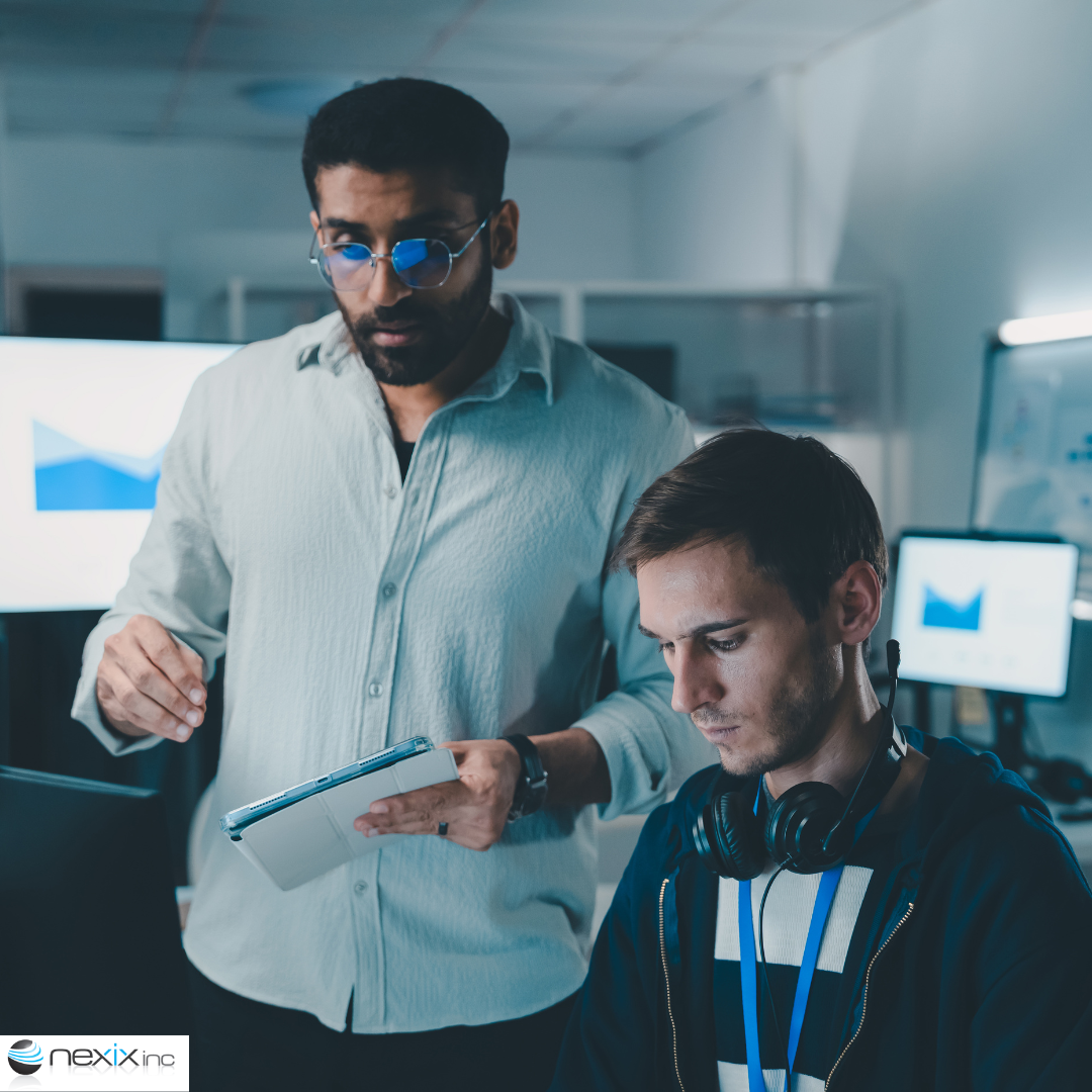 2 men talking in front of computers