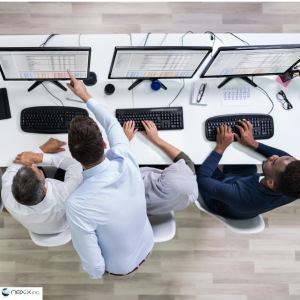 3 people seen from above looking at screens and working