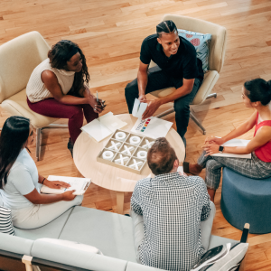 Team of 5 people seating in a circle and talking