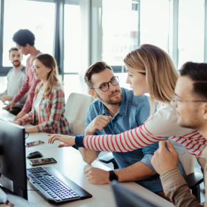 2 teams of 3 people talking at their desks